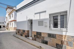 a white building with a window on a street at Apartamento Guzmán B in Barbate