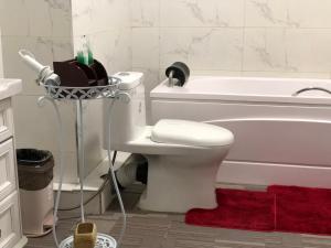 a bathroom with a white toilet and a bath tub at Eagle Town Serviced Apartment- Free Pick up from Airport in Ulaanbaatar