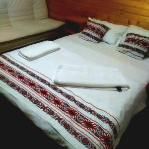 Una cama con toallas blancas y almohadas. en Căsuțele Camping AliMar, en Tîrsa 25 fotos más