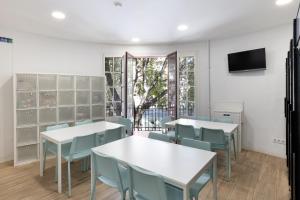 een eetkamer met tafels en stoelen en een tv bij LaResiBCN minimum 30 nights in Barcelona