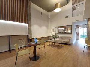 聖塞巴斯提安的住宿－Uma Suites Ondarreta，客厅配有桌椅和沙发