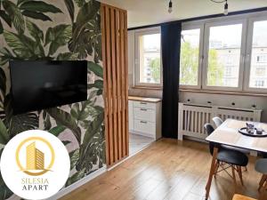 a living room with a tv on a wall at Apartament Miedziany in Tychy