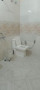 a bathroom with a toilet with a laptop on it at Uk09 hotel & Restaurant in Mussoorie