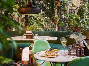 a table with a plate of food and a glass of wine at Sofitel Legend The Grand Amsterdam in Amsterdam