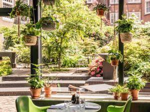 a patio with tables and chairs and potted plants at Sofitel Legend The Grand Amsterdam in Amsterdam
