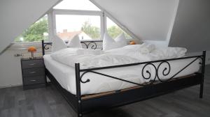 sypialnia z łóżkiem z białą pościelą i oknem w obiekcie Pension Haus Maria w mieście Mühlhausen
