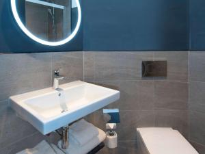 W łazience znajduje się umywalka, lustro i toaleta. w obiekcie ibis Styles London Gatwick Airport w mieście Crawley