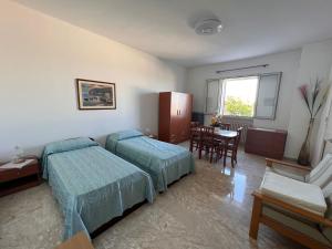 a hotel room with two beds and a table at Casa vacanze vista mare Salento Tricase Porto villa Antonio e villa Rosanna in Marina Porto
