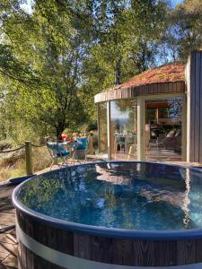Luxury romantic Roundhouse and hot tub for two في غلاسكو: مغطس كبير في حديقة خلفية مع منزل