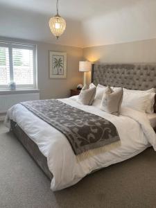 ein großes Schlafzimmer mit einem großen Bett mit weißer Bettwäsche und Kissen in der Unterkunft Orchard Cottage in Lincolnshire + 11 Fotos