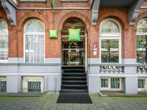 een groot bakstenen gebouw met een busbord erop bij ibis Styles Amsterdam City in Amsterdam