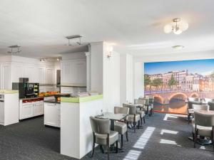a kitchen and dining room with a table and chairs at ibis Styles Amsterdam City in Amsterdam