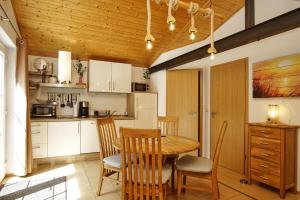 eine Küche und ein Esszimmer mit einem Holztisch und Stühlen in der Unterkunft Chalet Ostsee Haus Nr. 72 in Göhren