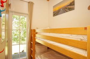 1 Schlafzimmer mit 2 Etagenbetten und einem Fenster in der Unterkunft Chalet Ostsee Haus Nr. 72 in Göhren