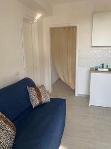 Una sala de estar con un sofá azul y una cocina. en le tre stelle, en Castellabate
