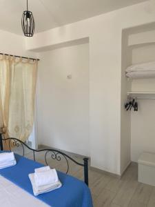 Un dormitorio con una cama azul con toallas. en le tre stelle, en Castellabate