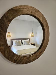 1 dormitorio con un gran espejo circular en la pared en Paraíso Azul, en Eira do Chão