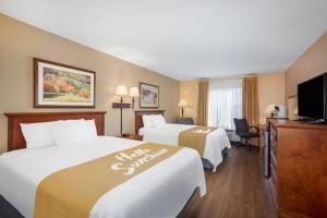 um quarto de hotel com duas camas e uma televisão de ecrã plano em Days Inn & Suites by Wyndham Cuba em Cuba