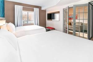een hotelkamer met 2 bedden en een televisie bij Quality Suites London in London