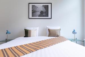 1 dormitorio con 1 cama blanca grande con una foto en la pared en Smartflats - Rogier Brussels, en Bruselas