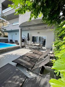 un patio avec une table et des chaises à côté d'une piscine dans l'établissement Villa Collis, à Makarska