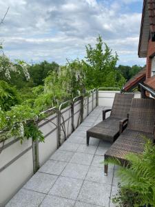a balcony with two benches and trees on a house at Ferienhof Kröger in Bielefeld