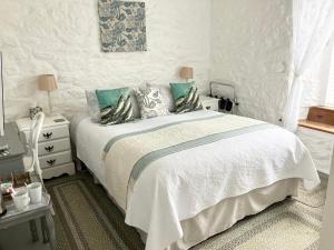 a white bedroom with a bed and a window at The Old Post House B&B in St. Just