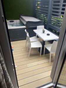 a balcony with a table and chairs and a table and a mattress at Arena Deluxe & Spa in Szeged
