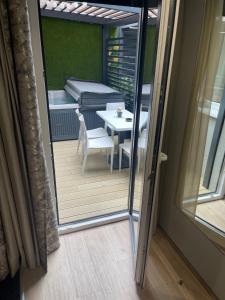 vista su un balcone con tavolo e letto di Arena Deluxe & Spa a Szeged