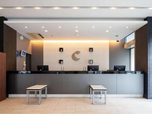 a lobby with a reception desk and two stools at Comfort Hotel Naha Prefectural Office in Naha