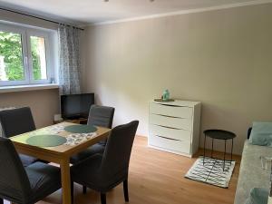 a living room with a table and chairs and a bedroom at Apartament w Zdroju in Duszniki Zdrój