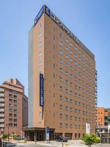 un edificio alto con un cartel encima en Comfort Hotel Niigata en Niigata