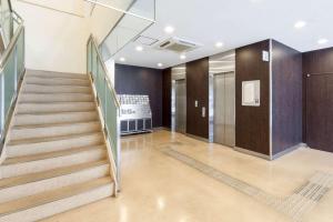 einen Flur mit einer Treppe in einem Gebäude in der Unterkunft Comfort Hotel Kokura in Kitakyūshū