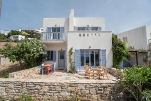 a white house with chairs and tables in front of it at Orkos View House in Plaka