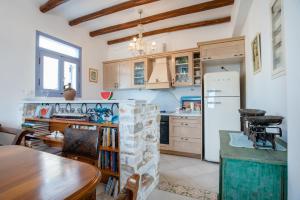 a kitchen with a table and a refrigerator at Orkos View House in Plaka