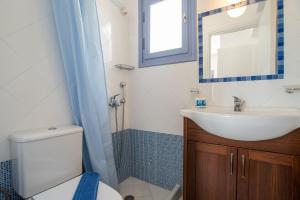a bathroom with a sink and a toilet and a mirror at Orkos View House in Plaka