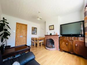 a living room with a fireplace and a flat screen tv at Rose House, with garden, ideal for couples and families with easy parking in Kent