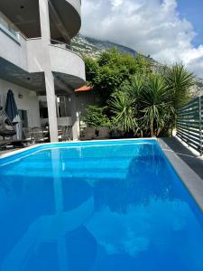 une grande piscine bleue en face d'une maison dans l'établissement Villa Collis, à Makarska