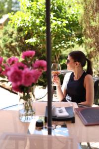 una mujer sentada en una mesa bebiendo una copa de vino en СПА-Готель "RESPECT" en Skhidnitsa