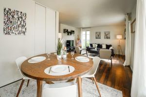 ein Esszimmer und ein Wohnzimmer mit Tisch und Stühlen in der Unterkunft Appartement avec Terrasse, Parking et WiFi, DisneyLand Paris in Chessy