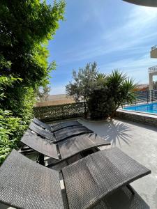 - un groupe de chaises en osier assis à côté d'une piscine dans l'établissement Villa Collis, à Makarska