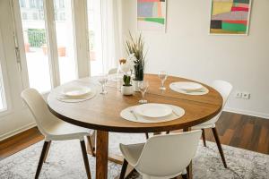 einen Esstisch mit weißen Stühlen und einem Holztisch in der Unterkunft Appartement avec Terrasse, Parking et WiFi, DisneyLand Paris in Chessy