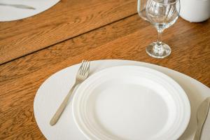 ein weißer Teller mit einer Gabel und einem Weinglas in der Unterkunft Appartement avec Terrasse, Parking et WiFi, DisneyLand Paris in Chessy + 15 Fotos