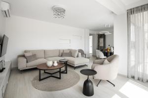 a living room with a couch and a table and chairs at Black Lotus Pool Villa, Afitos #FeelsLikeHome in Afitos