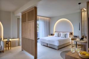 um quarto de hotel com uma cama e uma secretária em Ammos Luxury Resort em Mastihari