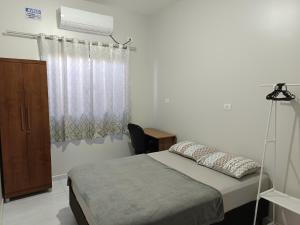 a bedroom with a bed and a chair and a window at Casa Gourmet Próx Marco Argentina Paraguai e Centro in Foz do Iguaçu