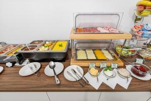 une table avec des assiettes, des ustensiles et d'autres denrées alimentaires dans l'établissement BlueBell Hotel, à Bratislava