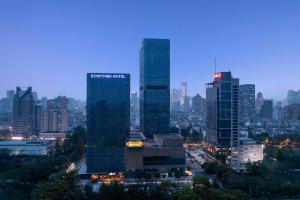 南京的住宿－南京凱賓斯基酒店，一群高大的建筑在晚上在城市里