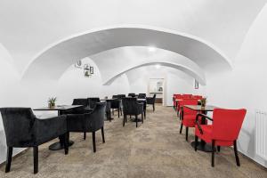 een eetkamer met tafels en rode stoelen bij BlueBell Hotel in Bratislava
