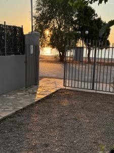 una puerta abierta con una valla en un parque en Akrotiri Luxury Suites en Trápeza